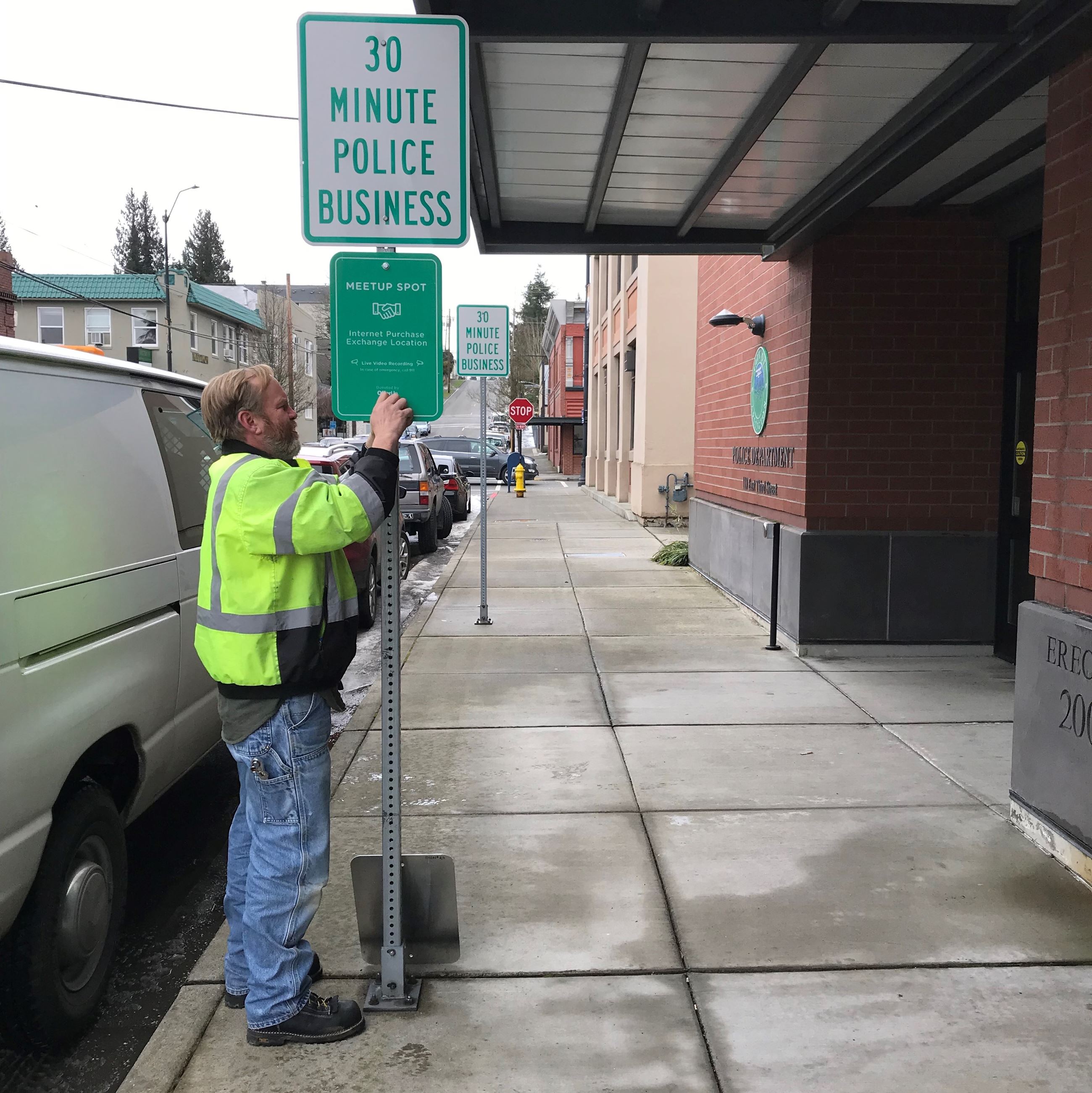 Maintenance Worker II Scott Black posts the Community MeetUp sign in front of the Arlington Police S