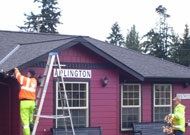 Person on Ladder Repairing Red Building