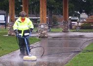 Person Cleaning Sidewalk