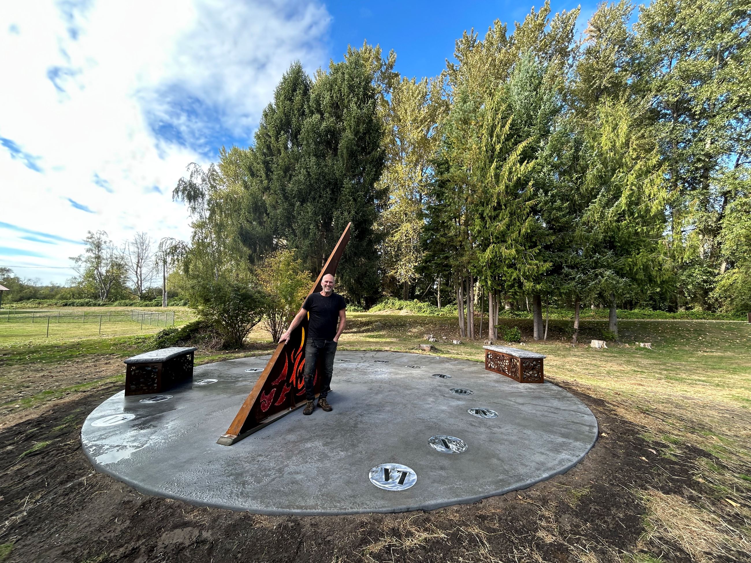 sundial artwork with artist in park